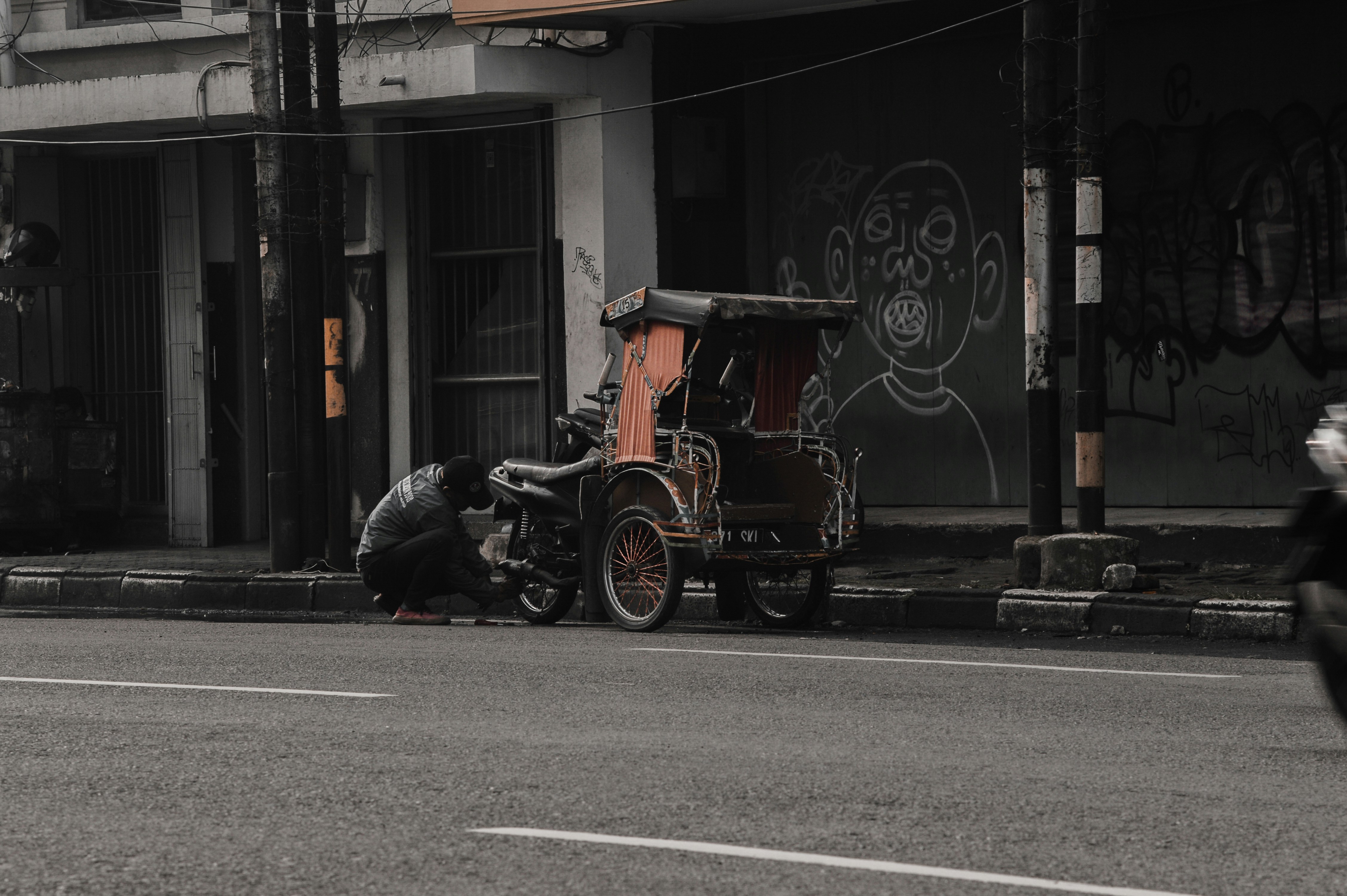 a person kneeling next to a motorcycle